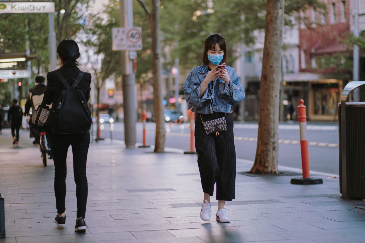 woman walking outside wearing facemask